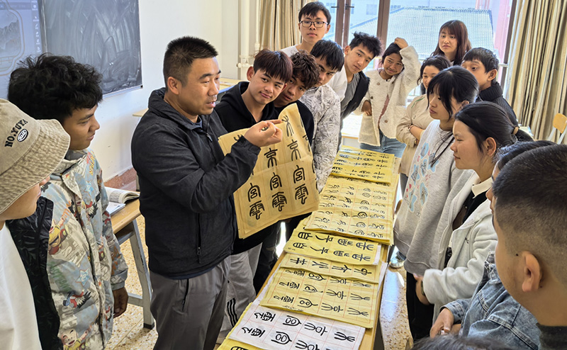 徐润刚用手语为学生们讲解书法篆刻。星空游戏app推荐免费供图